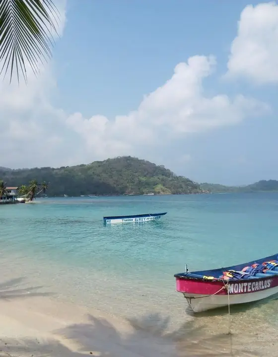 Playa de aguas turquesa con una lancha en Portobelo