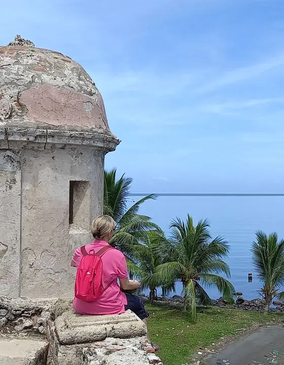 Viajera junto a una garita colonial frente a la bahía de Portobelo
