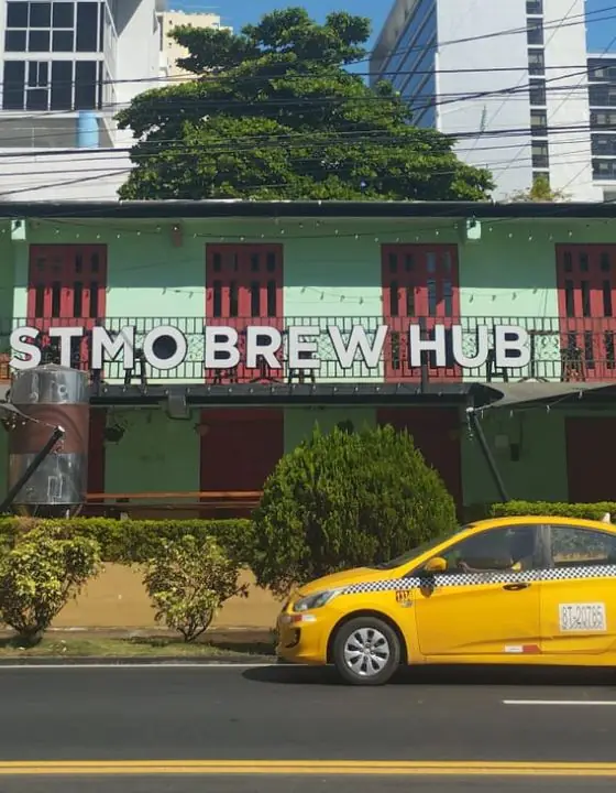 Casa colonial verde con un taxi amarillo en Ciudad de Panamá