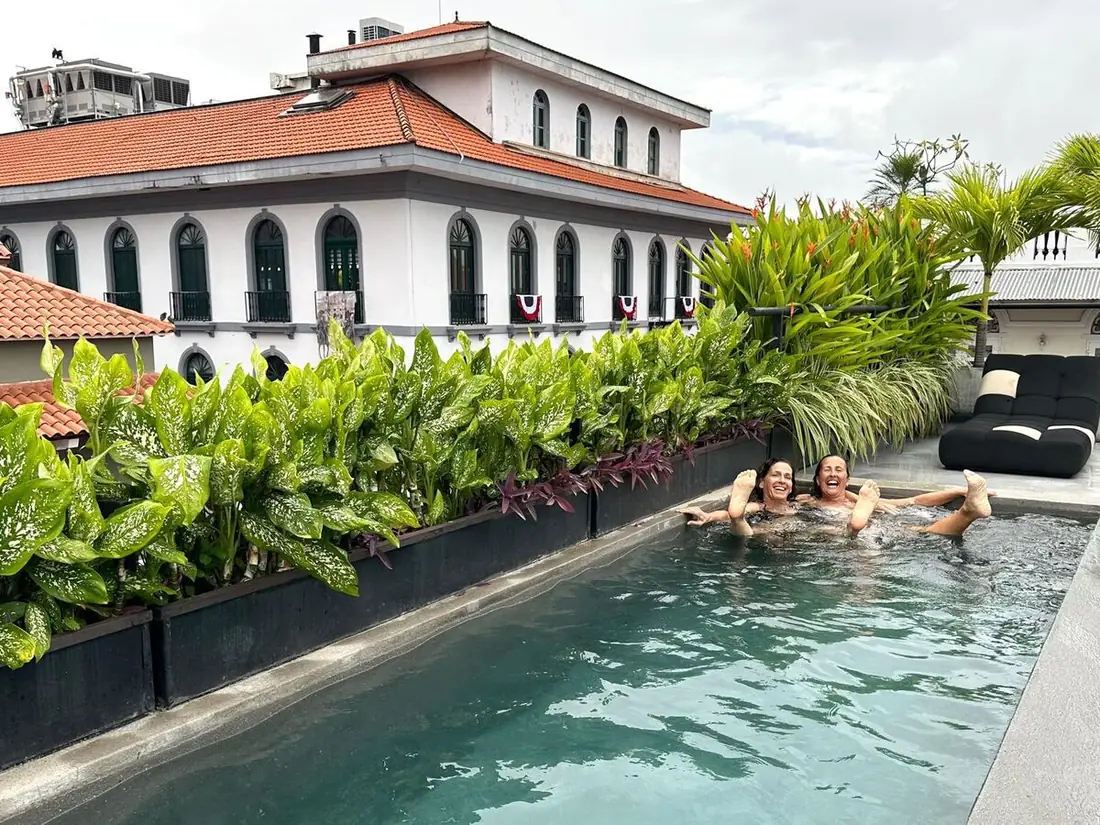 Dos viajeras riendo en la piscina de una azotea del Casco Viejo