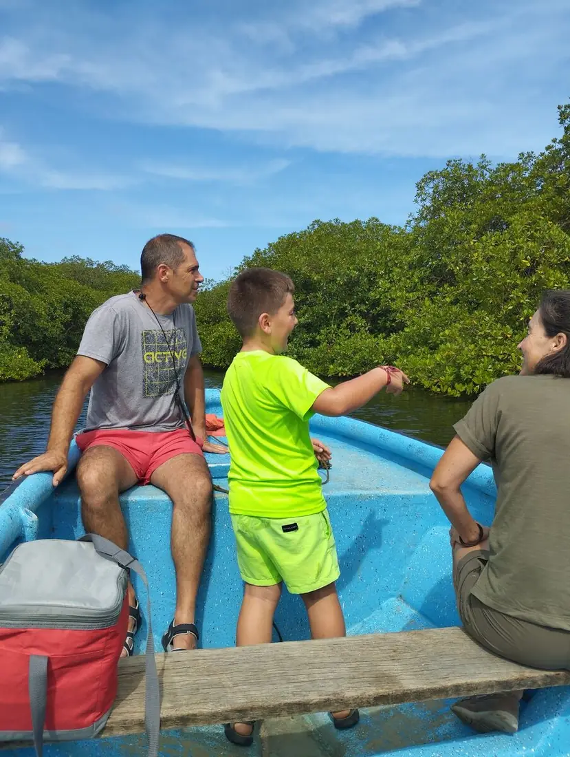 Familia en una lancha azul recorriendo los manglares