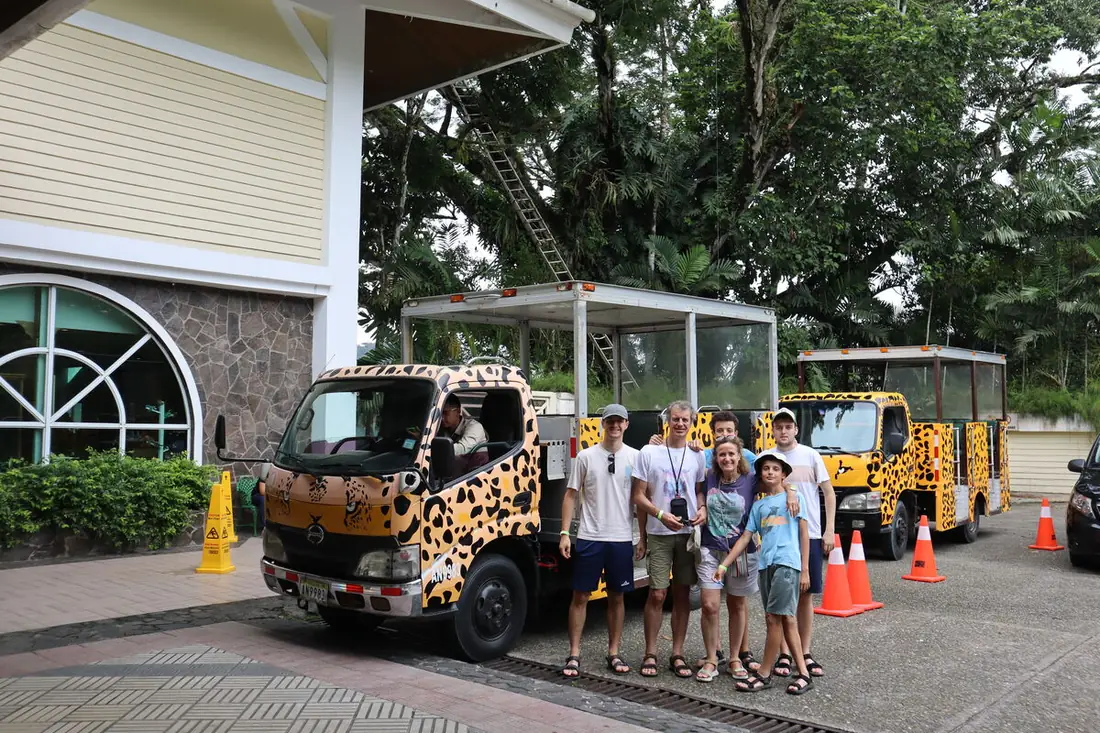 Familia junto a los vehículos con dibujo de jaguar de un hotel en la selva