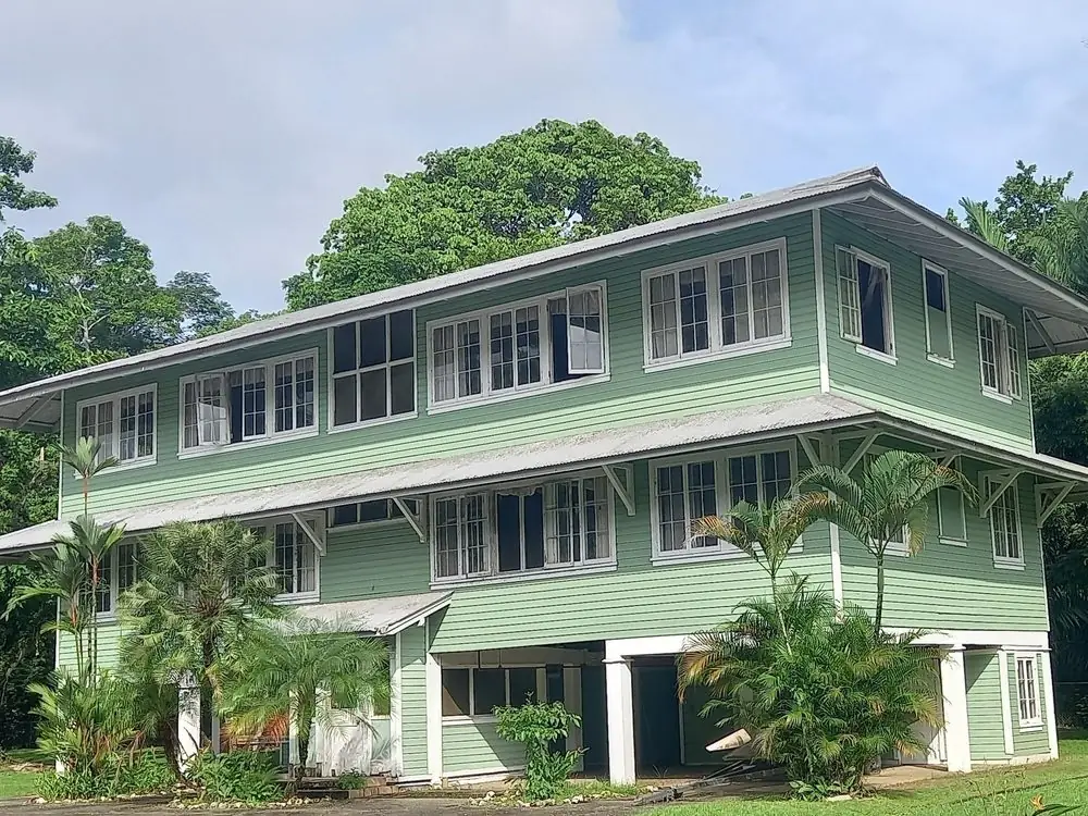 Casa de madera verde rodeada de selva en la zona del Canal